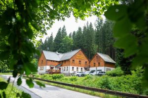 a large building with cars parked in front of it at Hotýlek pod smrkem in Harrachov