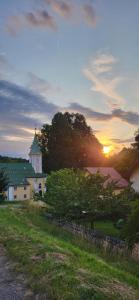 a white house with a green roof and a sunset at Tinyhouse am Bach, 3144 Wald in Wald