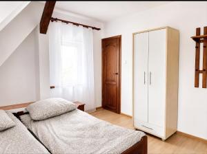 a bedroom with a bed and a cabinet at Pensjonat Rowy Blisko Morza in Rowy