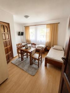 a living room with a table and chairs and a kitchen at Pensjonat Rowy Blisko Morza in Rowy