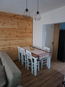 a dining room with a table and white chairs at Apartman Jana in Žabljak