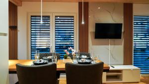 a dining room with a table and chairs and a television at Chalet du calme Augsburg in Augsburg
