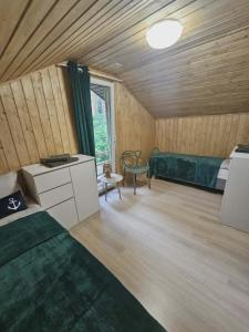 a bedroom with a bed and a couch in a room at Sosnowa Ostoja Jurata in Jurata