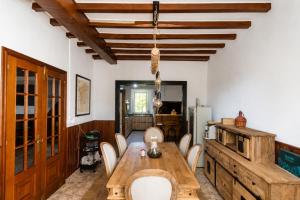 a dining room with a wooden table and chairs at Rivera de Poulo in Ordes