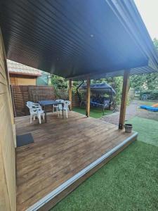 a wooden deck with a picnic table and a gazebo at Sosnowa Ostoja Jurata in Jurata
