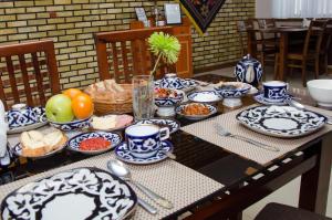 a table with blue and white plates and bowls of food at Jipek Joli Inn in Nukus