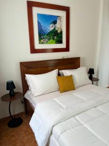 a bedroom with two white beds and a picture on the wall at SWISS Residence Denver in Douala