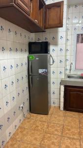 a kitchen with a stainless steel refrigerator in a kitchen at SWISS Residence Denver in Douala