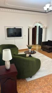 a living room with a green couch and a table at SWISS Residence Denver in Douala