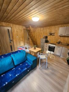 a living room with a blue couch and a table at Sosnowa Ostoja Jurata in Jurata