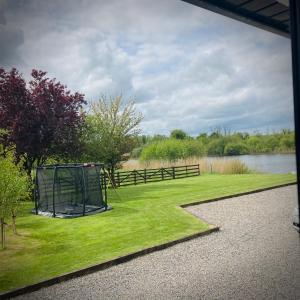 a view of a yard with a fence and water at Quiet Riverside Stopover by the Shannon in Leitrim
