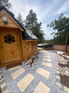 a wooden dog house with a stone walkway at Kota Évasion & Spa in Cahors