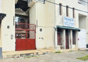 a building with a red door on the side of it at T2 en centre ville in Cayenne