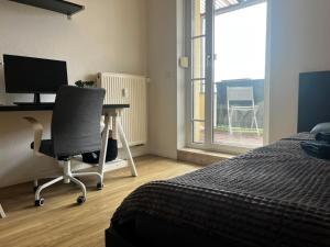 a bedroom with a desk and a chair and a computer at Ruhiger Flussblick vom Balkon all-in 5G in Gera