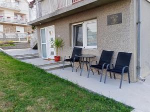 a patio with chairs and a table in front of a building at Apartman biserna Sofija in Topola