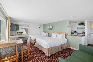 a hotel room with two beds and a kitchen at The Corsair & Cross Rip Oceanfront in Dennis Port