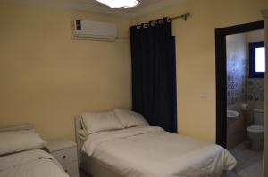 a bedroom with two beds and a black curtain at Pool View Chalet in El Alamein