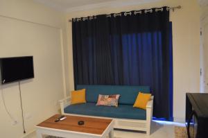 a living room with a blue couch in front of a window at Pool View Chalet in El Alamein