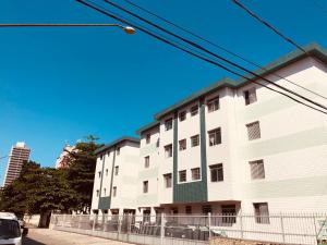 a large white building on the side of a street at Lindo Apartamento na Guilhermina PG in Praia Grande