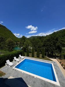 a swimming pool with chairs and a view of a mountain at Villa Pjene in Konjic +31 photos