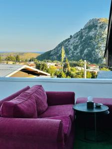 a purple couch sitting on a balcony with a table at MorePlanina in Sutomore