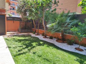 a garden with grass and trees and a fence at Eden Bay Vacation Home in Ladispoli