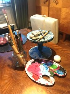 a wooden table with paint brushes and a plate on it at The Creative Studio Apartment in Piteå