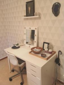 a white desk with a mirror and a chair at The Creative Studio Apartment in Piteå