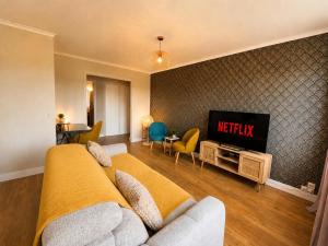 a living room with a couch and a tv at Le Panorama Chic 4prs-Parking in Bourg-en-Bresse