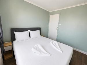 a white bed with two white towels on top of it at Le Panorama Chic 4prs-Parking in Bourg-en-Bresse