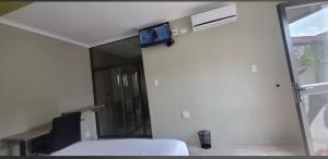 a bedroom with a bed and a tv on the wall at Rundu Rainbow Guesthouse in Rundu