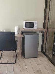a microwave sitting on a table with a chair at Rundu Rainbow Guesthouse in Rundu