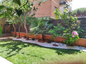 a garden in front of a building with trees and plants at Eden Bay Vacation Home in Ladispoli