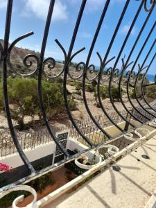 a wrought iron fence with a view of the beach at calm appart in Agadir +2 photos