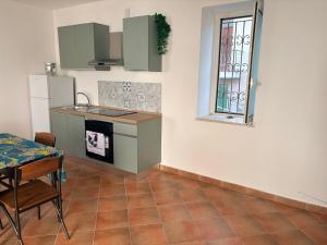 a kitchen with green cabinets and a table and a window at La Terrazza in Ortona