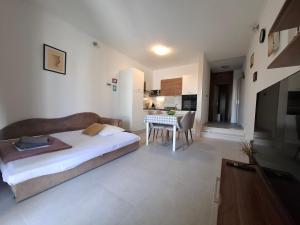 a bedroom with a bed and a dining room with a table at Apartman Terrazza in Sumartin