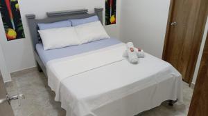 a bed with a teddy bear sitting on top of it at Hotel Panther Resort in Necoclí