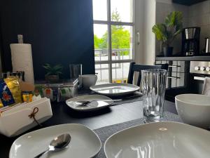 a kitchen table with two white plates and a glass at Stylische Flat1 mit französischem Balkon1 all-in 5G in Gera