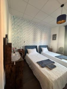 a bedroom with two beds and a blue and white wall at El Palmar in Tobarra