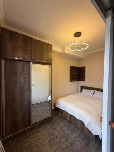 a bedroom with a bed and a sliding glass door at Didveli Mountain Apartment in Bakuriani