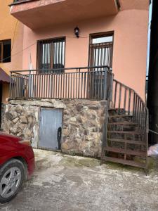 a red car parked in front of a building at Didveli Mountain Apartment in Bakuriani
