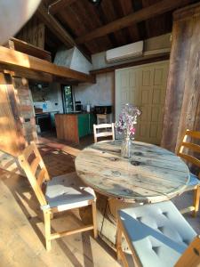 a wooden table with chairs and a vase of flowers at Can Cirili Rustic Romantic apartment for couples or family events in Bordils