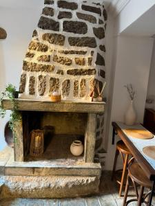 a stone fireplace in a room with a table at Dukes place in Mestá