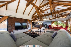 a living room with a large couch and a tv at Holiday Residence Banfi in Štrigova
