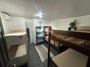 a dorm room with two bunk beds and a hallway at Vista Surf Pipa Hostel in Pipa