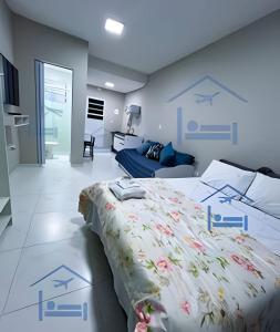 a bedroom with a bed and a couch at Estadia Perfeita com AC, Apto a minutos do Aeroporto Gru in Guarulhos