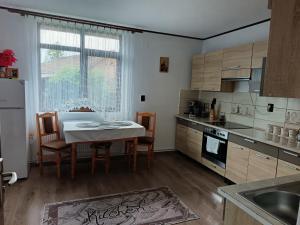 a kitchen with a table and chairs and a table and a kitchen with at Pensiunea Narcisa cu Ciubar in Mălăeşti