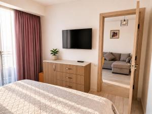 a bedroom with a bed and a flat screen tv at Your Beach Tower in Batumi +12 photos