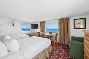 a hotel room with two beds and a desk at The Corsair & Cross Rip Oceanfront in Dennis Port