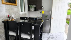 a kitchen with a black counter and a refrigerator at Apartamento Decrusi in Alajuela